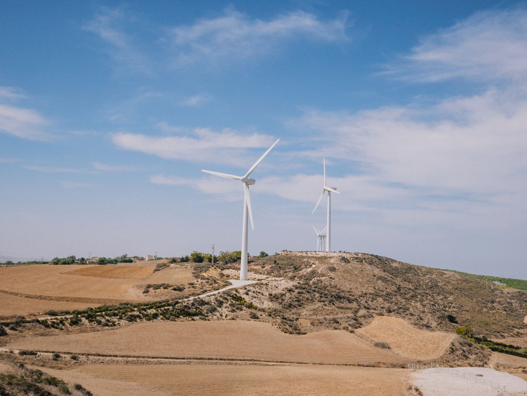 wind turbines on a hillside with a blue sky